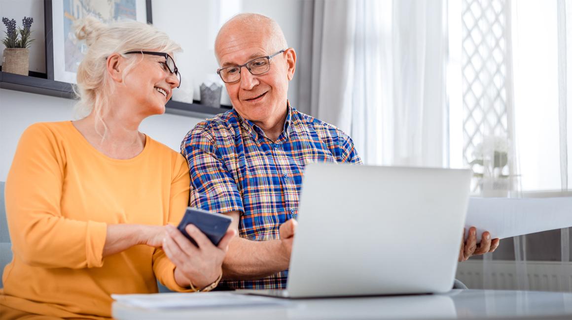 starsza pani z komórką, starszy an z laptopem, smieją się