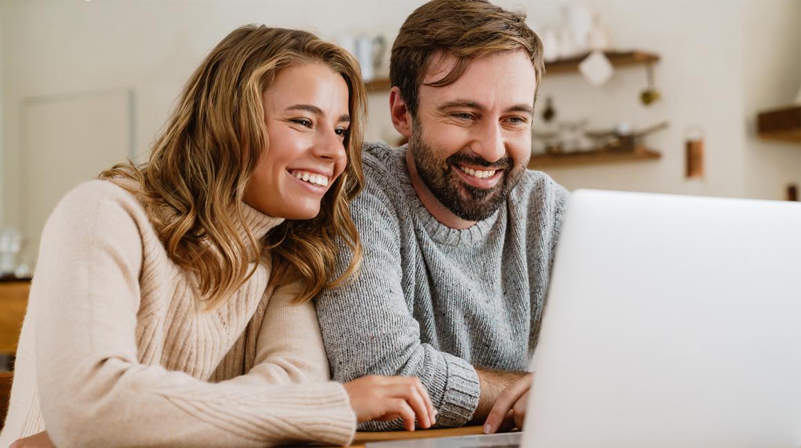 Małżeństwo przed laptopem z uśmiechem