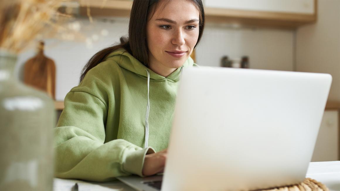 kobieta w zielonym dresie, pulchna, przed laptopem