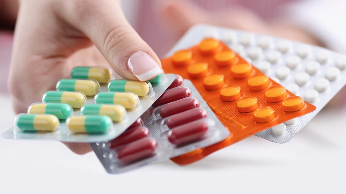 dłoń kobiety z blistrami leków