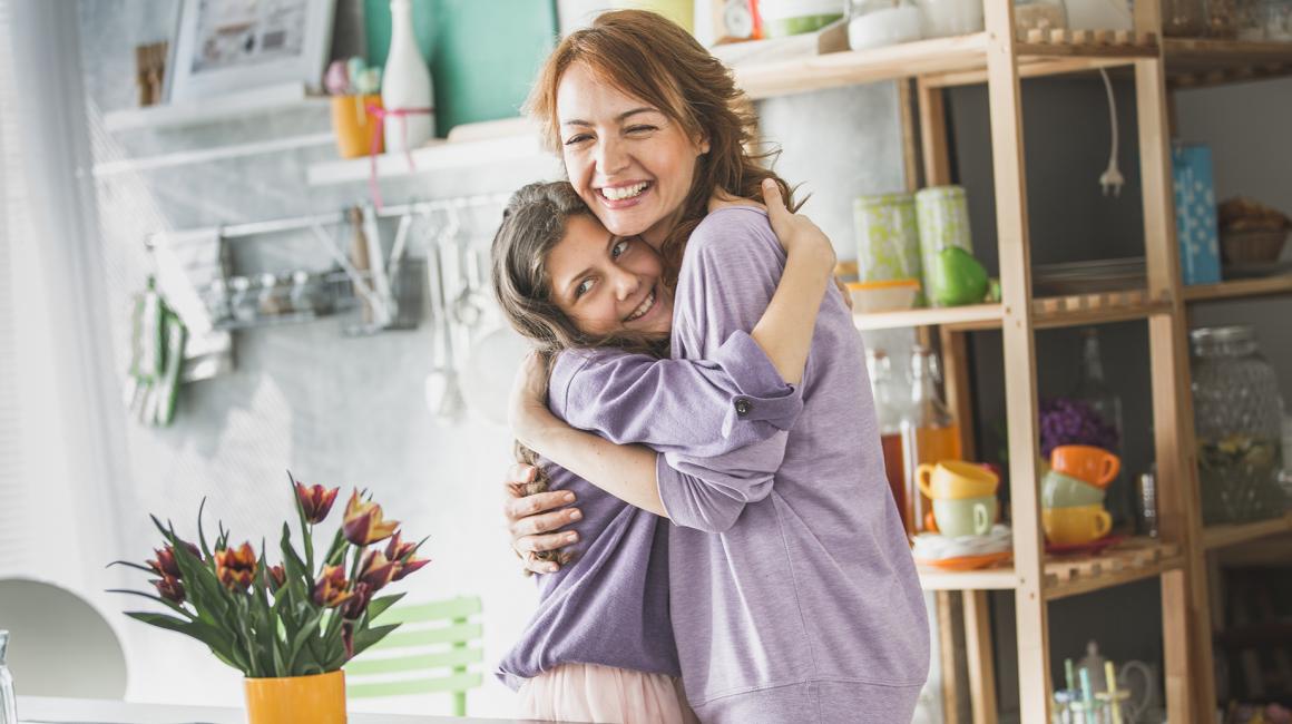 Matka obejmująca córkę, z tyłu tulipany