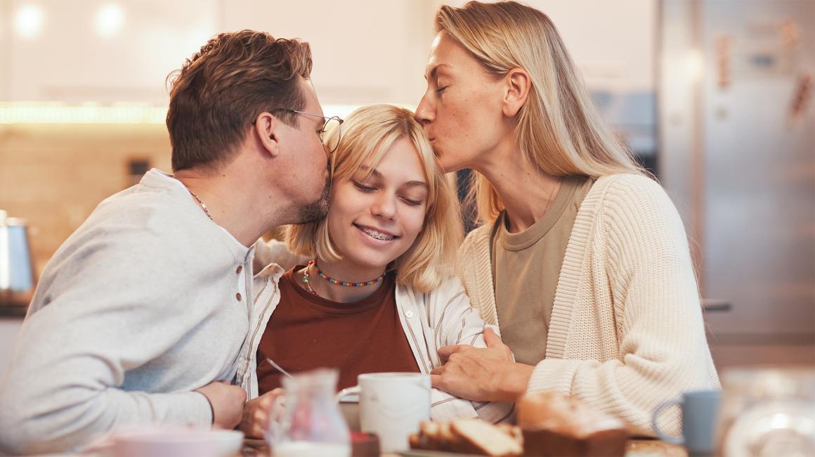 Rodzice obejmują i całują nastolatkę