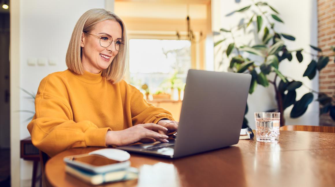 Kobieta w żołtej bluzie przed komputerem