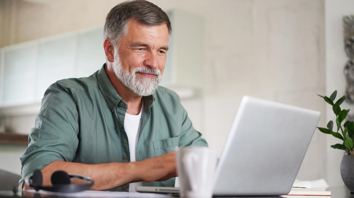 pan z siwą brodą przed komputerem