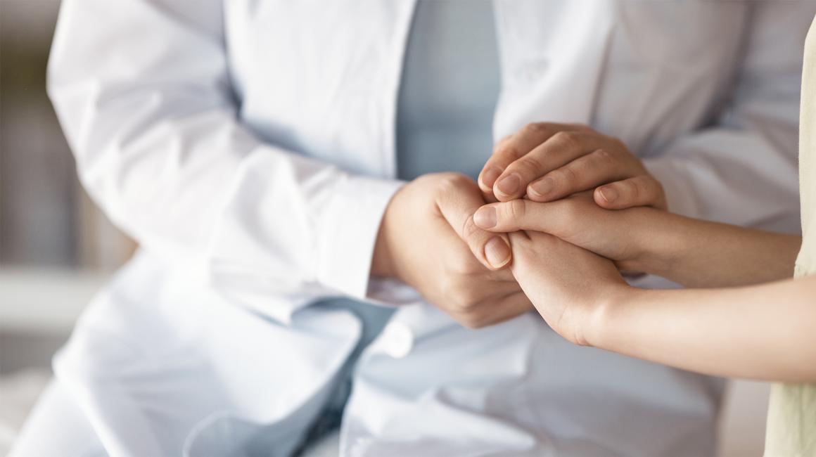 Lekarz trzyma pacjenta za rece