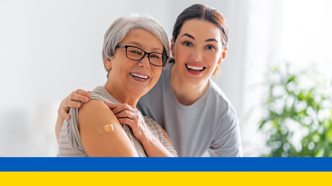 młodakobieta ze starszą po szczepieniu, na dole flaga Ukrainy