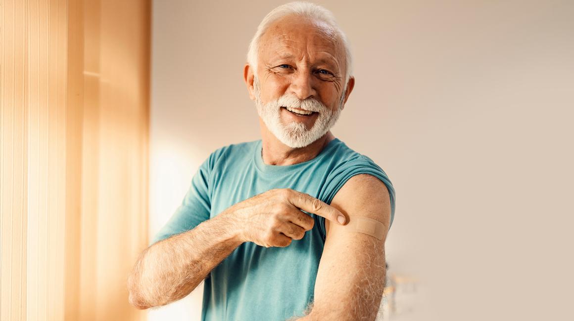 Starszy pan pokazuje ramię po szczepieniu