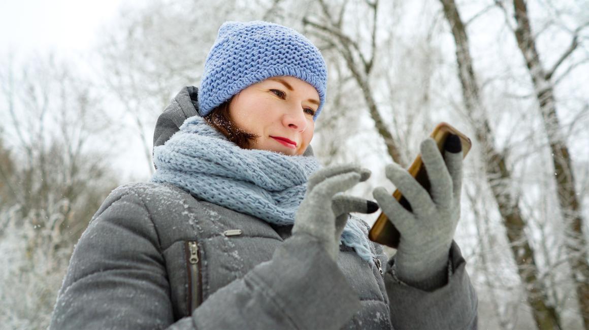 dziewczyna w czapce i kurtce na spacerze z komórką w reku