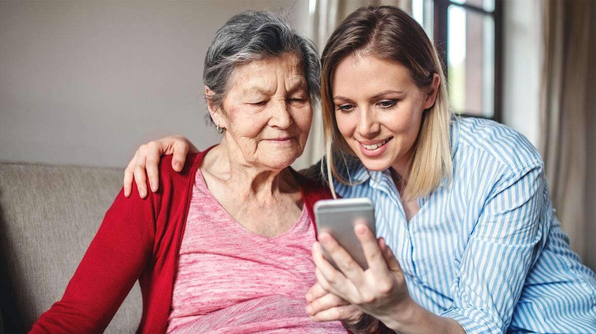 Mloda kobieta pokazuje starszej cos na telefonie