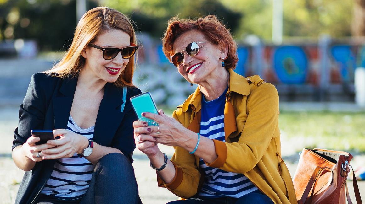 dwie panie w średnim wieku z komórkami, coś sobie tłumaczą