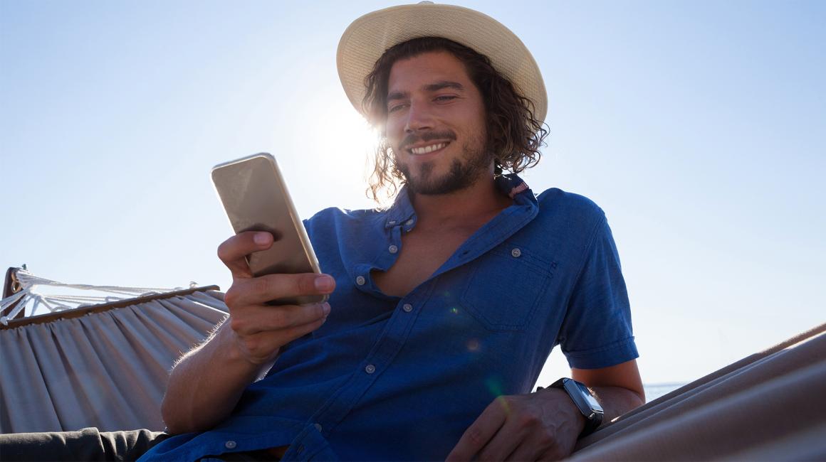 młody meżczyzna w kapeluszu z komórka