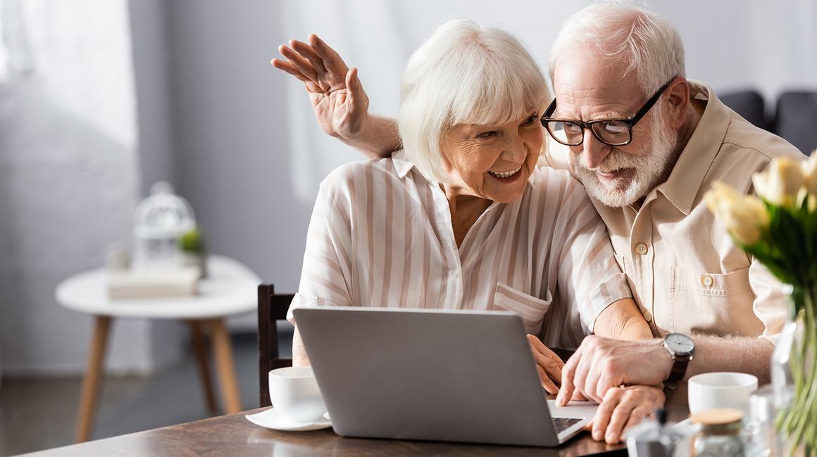 starsza para przy laptopie na kanapie