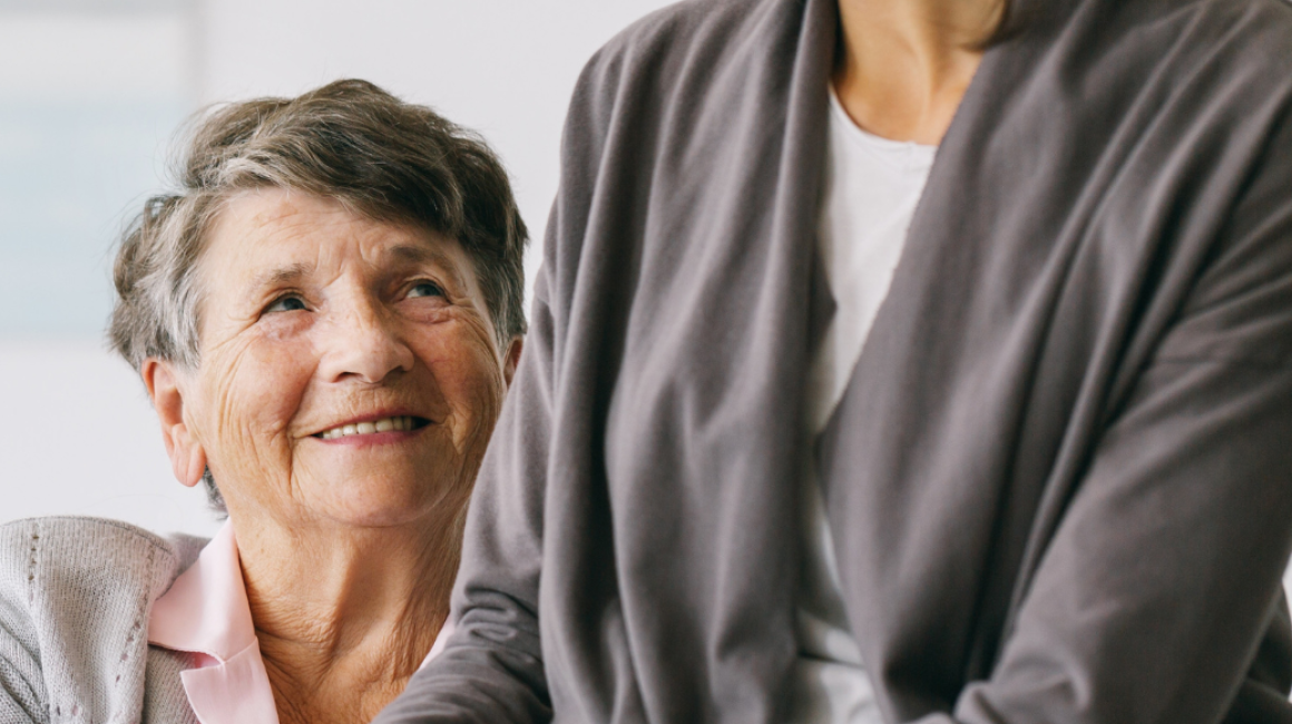 Dwie kobiety, starsza i młodsza, trzymają się za ręce