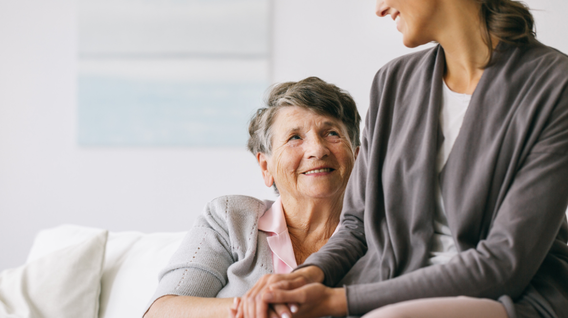 Dwie kobiety, starsza i młodsza,trzymają się za ręce