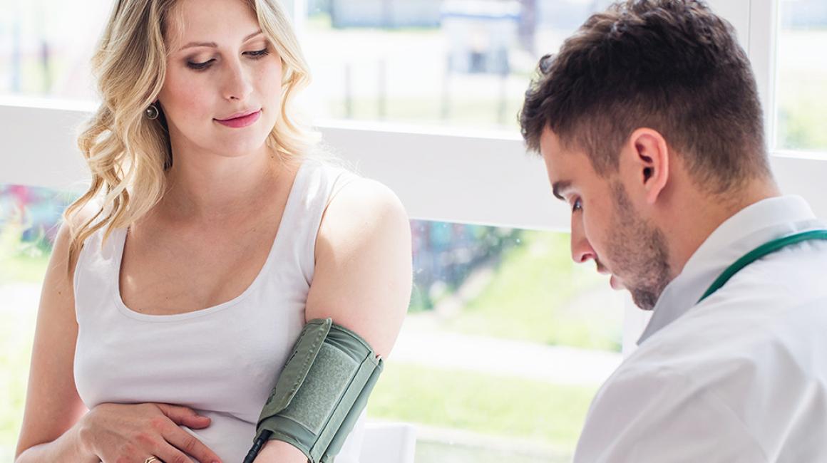 lekarz bada cisnienie ciężarnej kobiecie