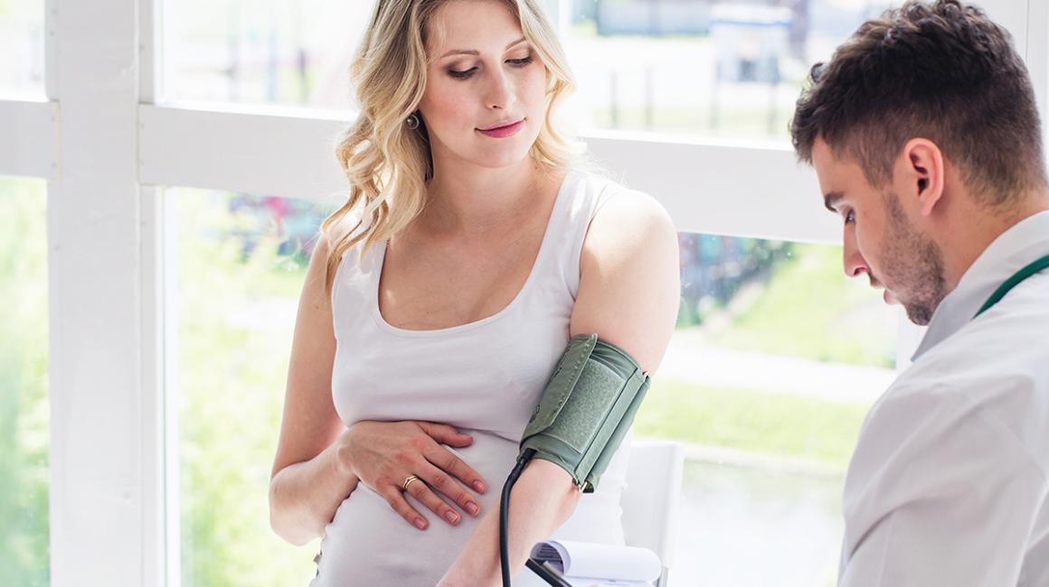 lekarz bada cisnienie ciężarnej kobiecie