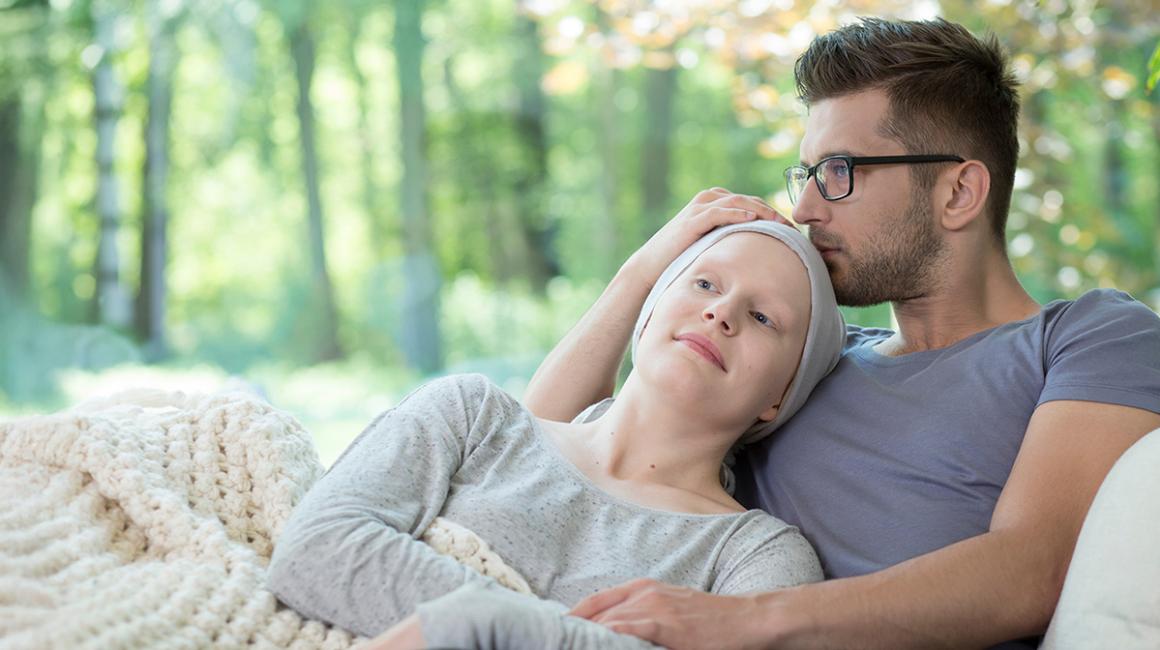 kobieta z chustką na głowie i mężczyzna na sofie