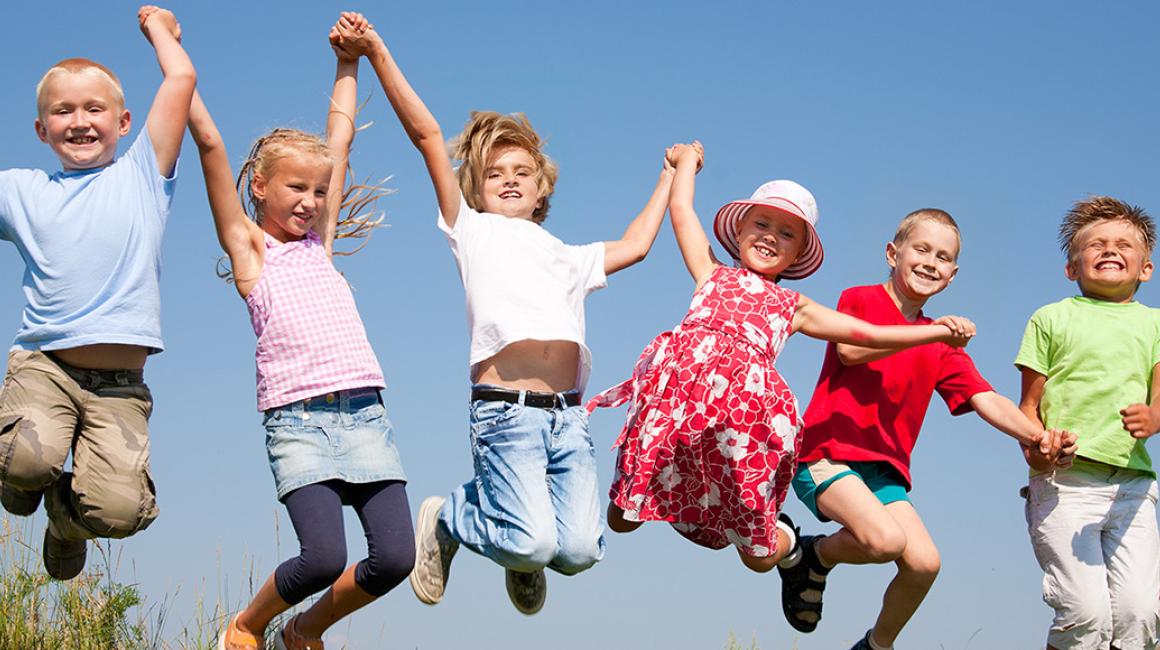 dzieci radośnie skaczą na łące