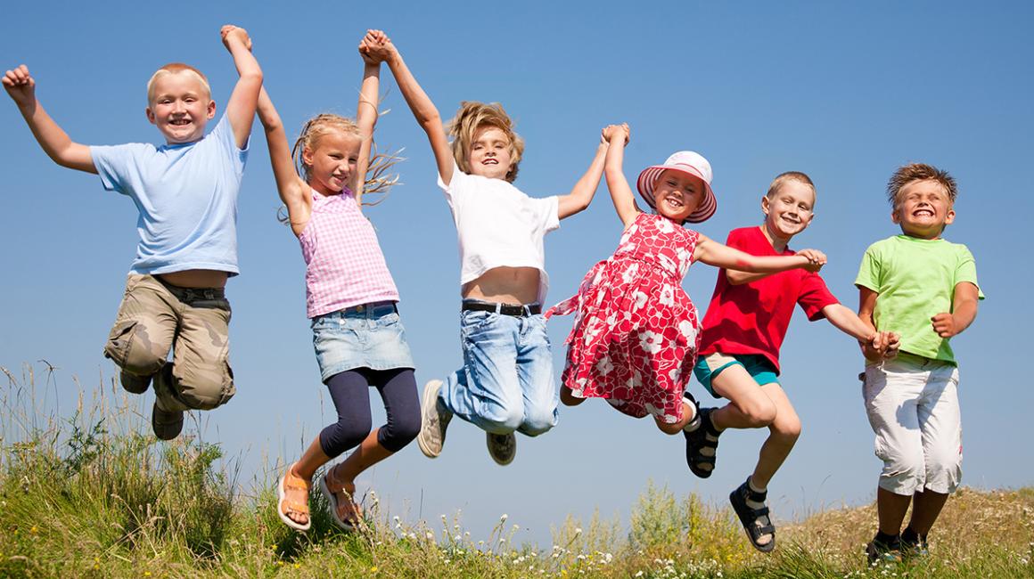 dzieci radośnie skaczą na łące