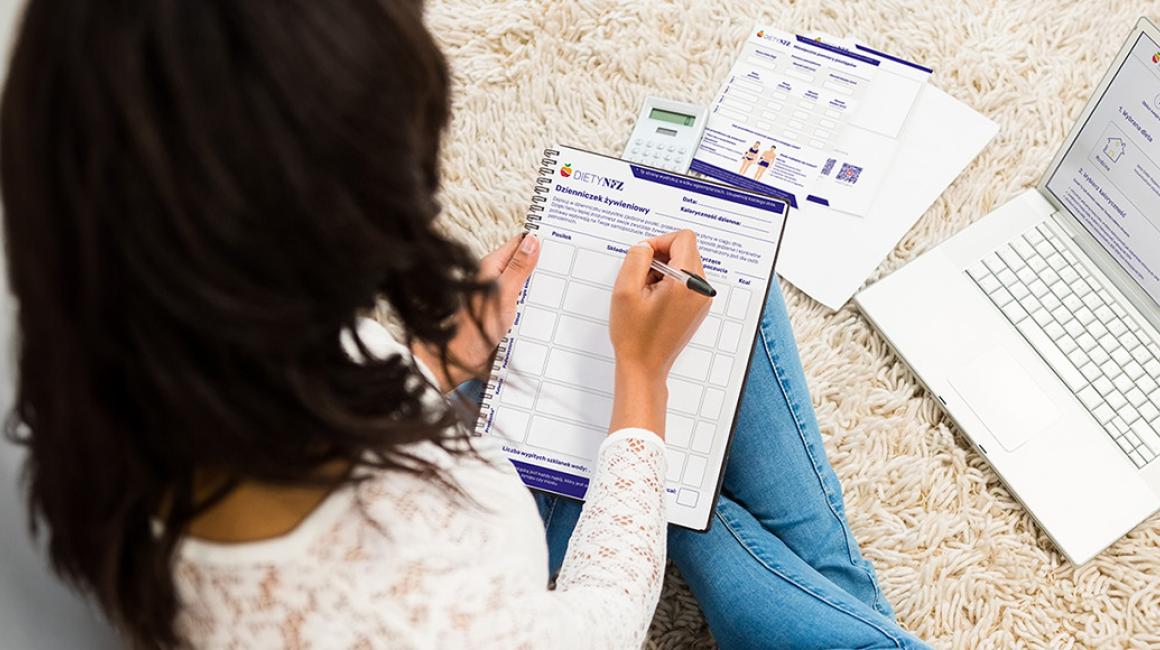 kobieta pisze w dzienniczku żywieniowym