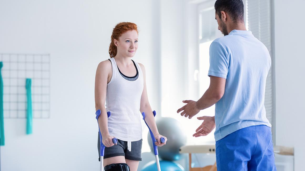 kobieta o kulach rozmawia z fizjoterapeutą