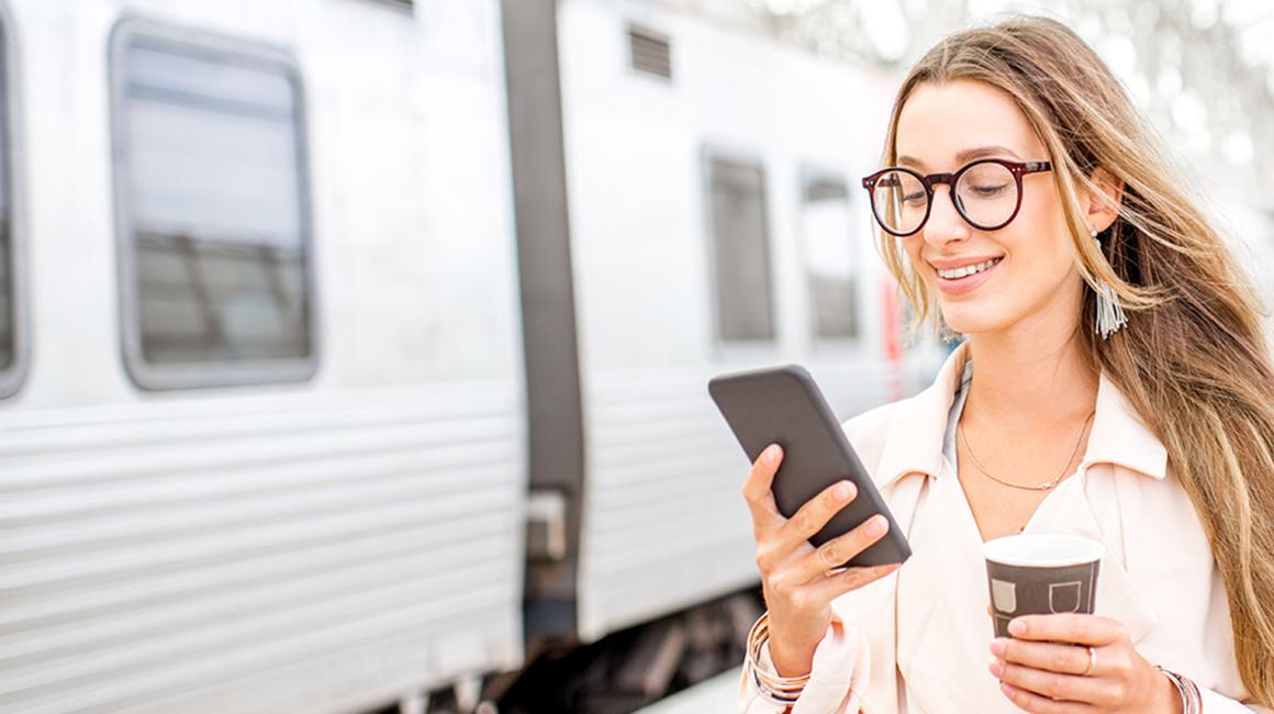 dziewczyna z długimi włosami na peronie z komórką w ręku