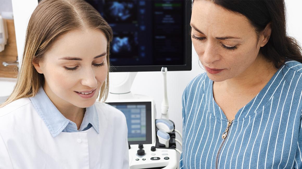Pacjentka rozmawia z lekarką, która pokazuje jej wyniki