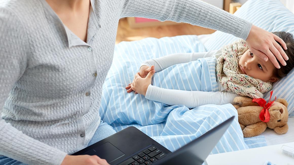 Matka sprawdza czolo córki i ma otwarty kompuer na kolanach