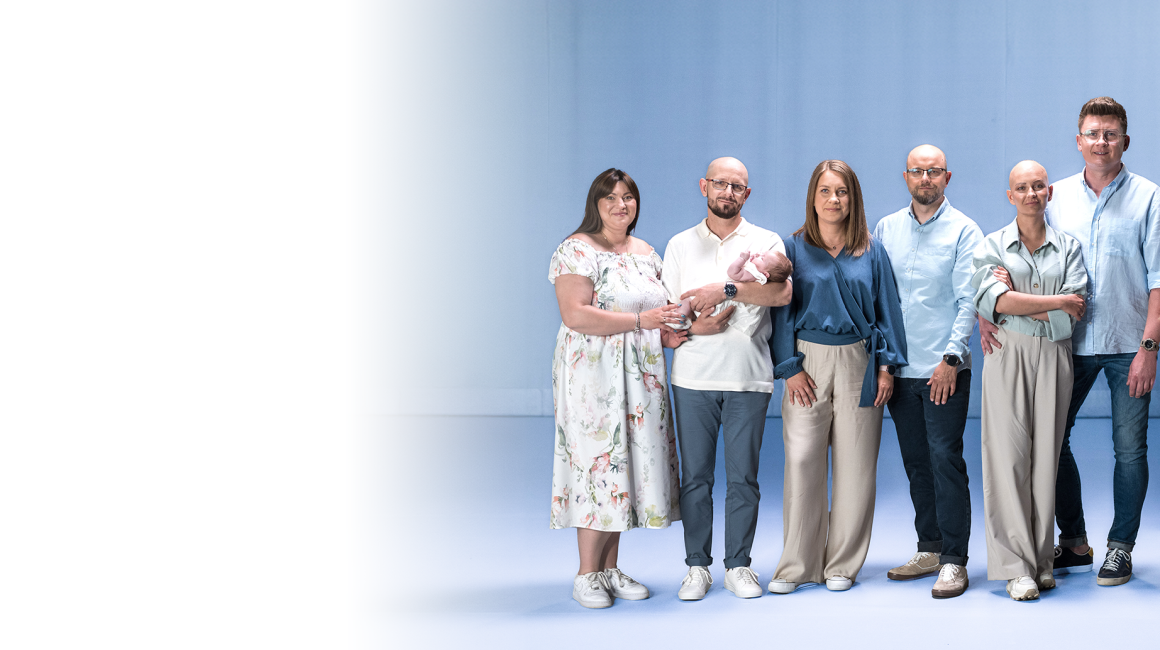 Trzy stojące pary. Jeden z mężczyzn trzyma małe dziecko na ręku.