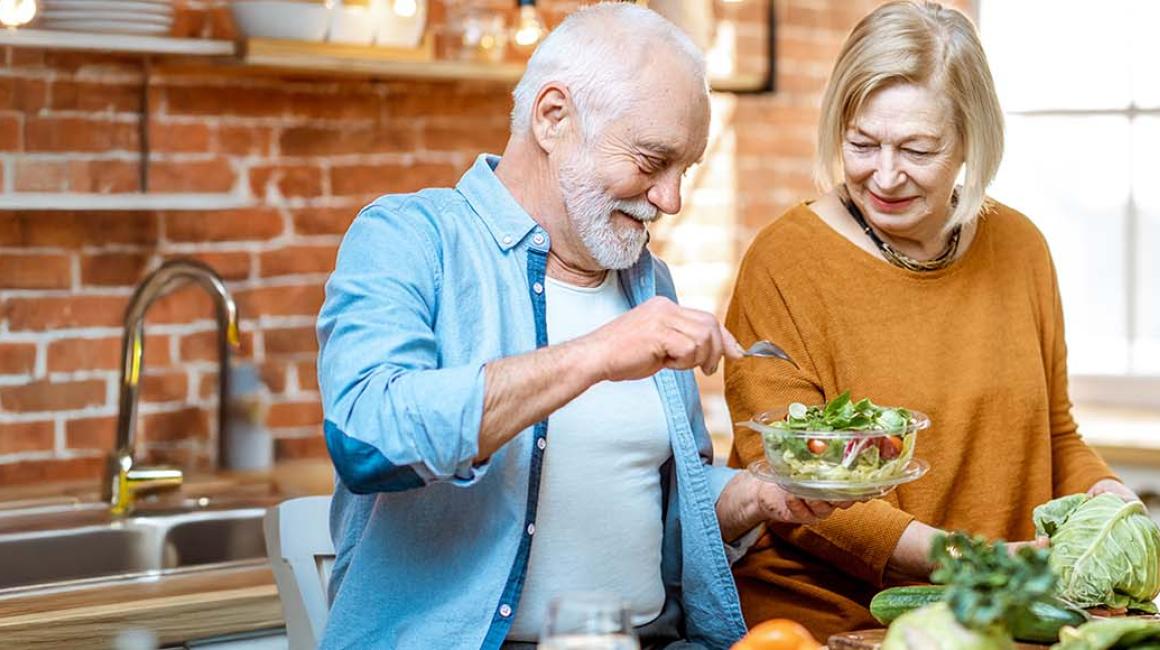kobieta i mężczyzna w wieku senioralnym przygotowują posiłek