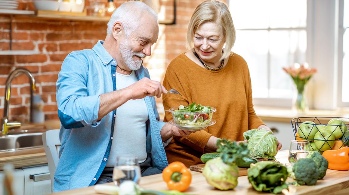 kobieta i mężczyzna w wieku senioralnym przygotowują posiłek