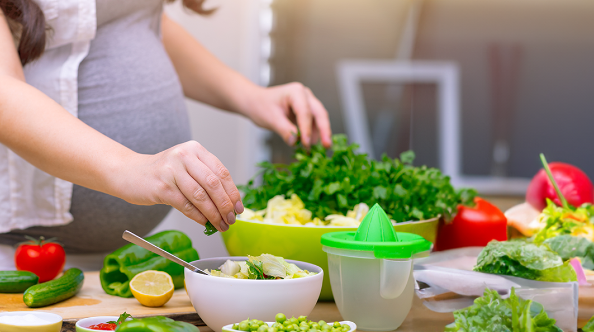 Kobieta w ciąży gotuje