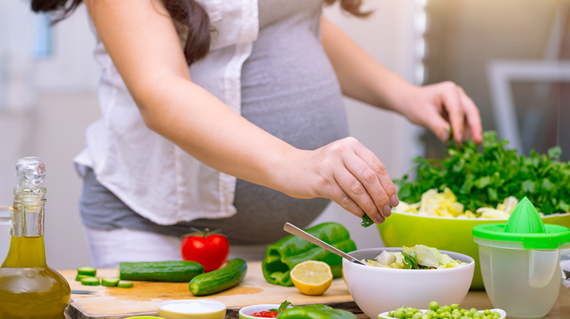 kobieta w ciąży gotuje.