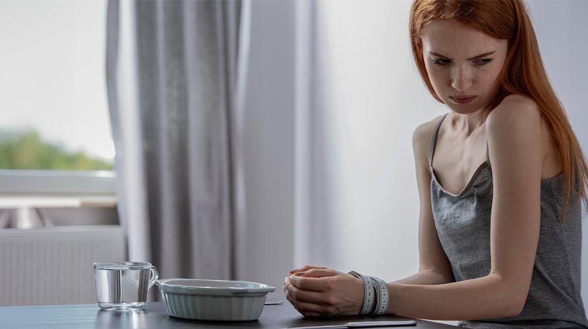 kobieta siedzi przy pustym talerzu