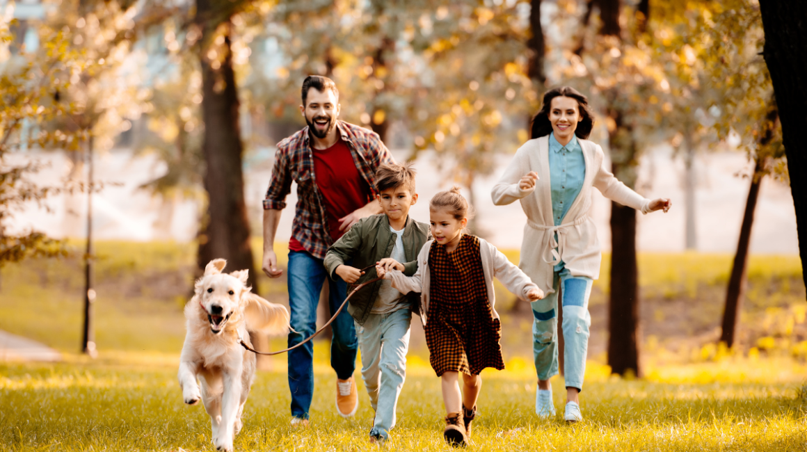 Rodzina biegnie po parku z psem
