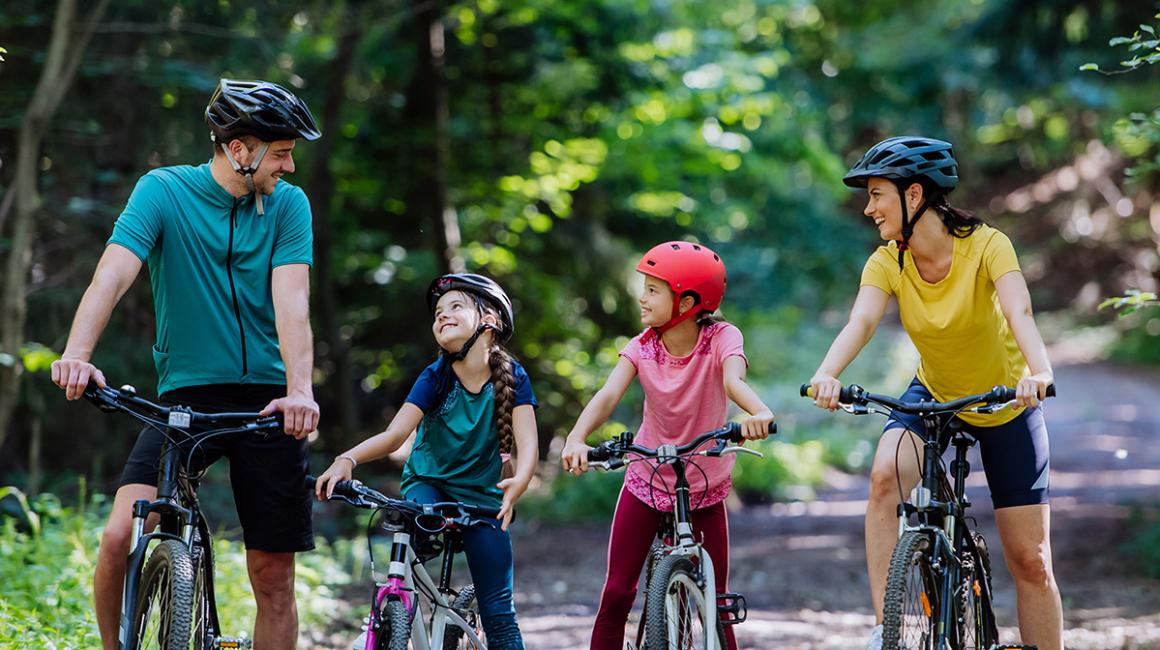 rodzice z dwójką dzieci na rowerach