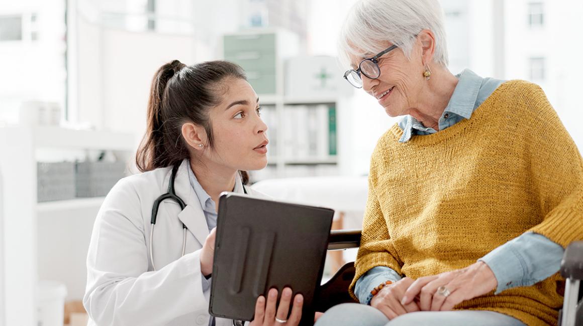 lekarka rozmawia ze starszą kobietą na wózku