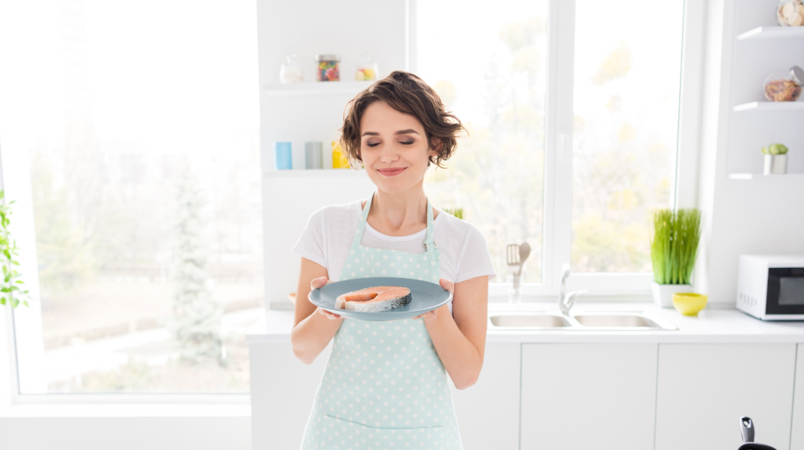 pani trzyma rybę na talerzu