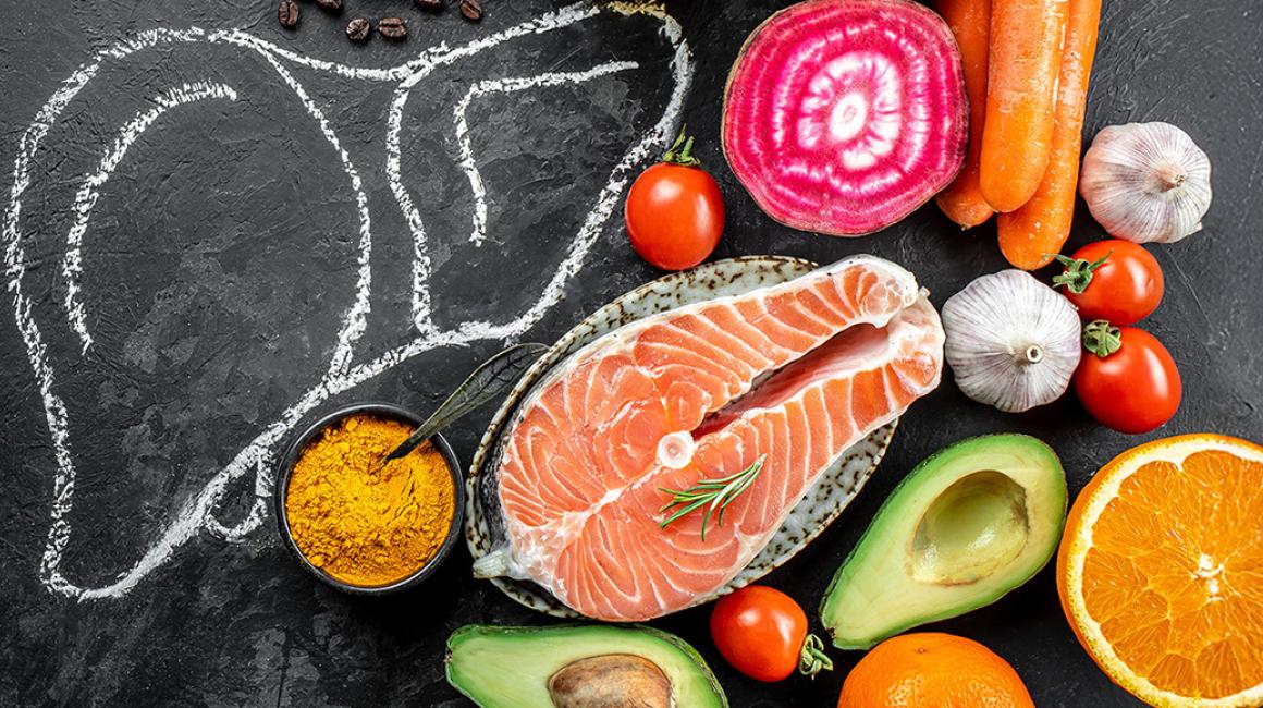 wątroba narysowana kredą na tablicy, obok warzywa i łosoś