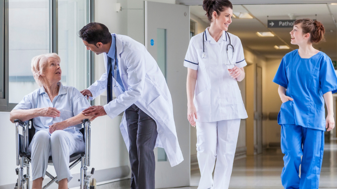 lekarze i pacjentka na wózku na kortarzu szpitala