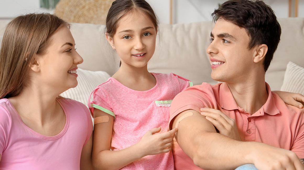 Mama, tata i córka z plastarmi po szczepieniu na ramionach