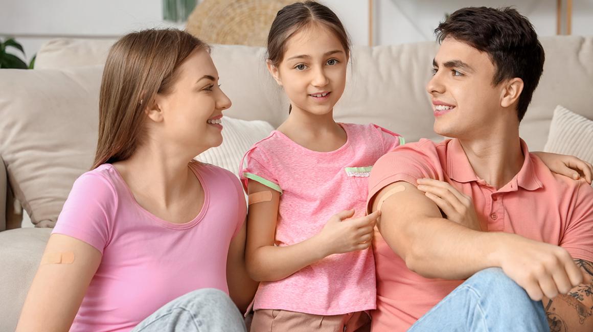 Mama, tata i córka z plastrami po szczepieniu na ramionach