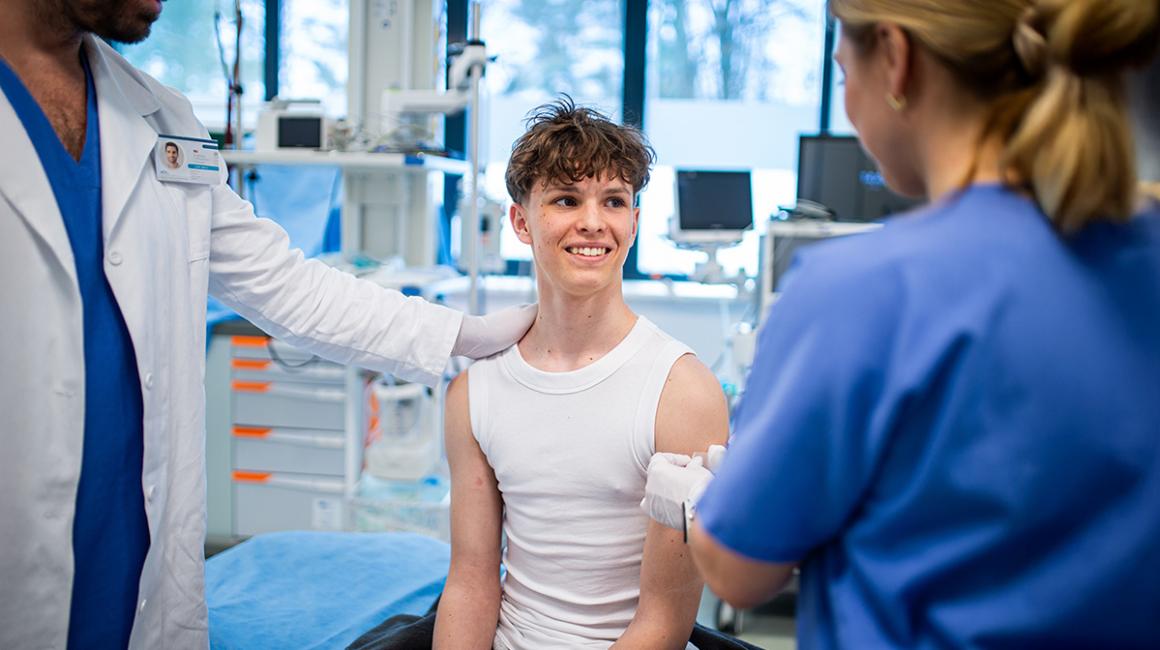 mlody chlopak w trakcie szczepienia