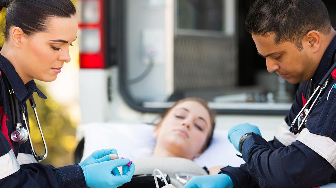 Dwoje ratowników z chorą na noszach