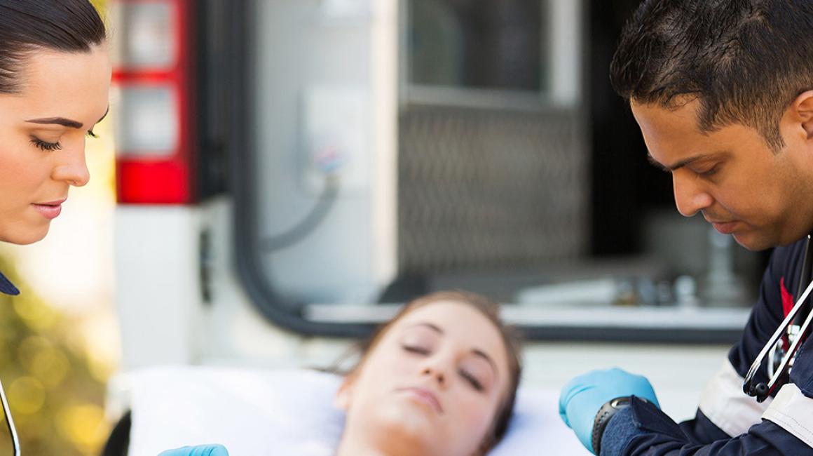 Dwoje ratowników z chorą na noszach