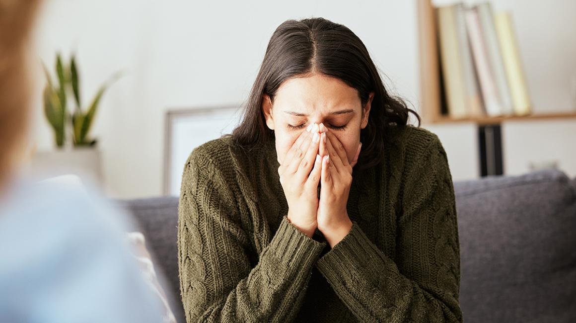 Młoda kobieta trzyma twarz w dłoniach