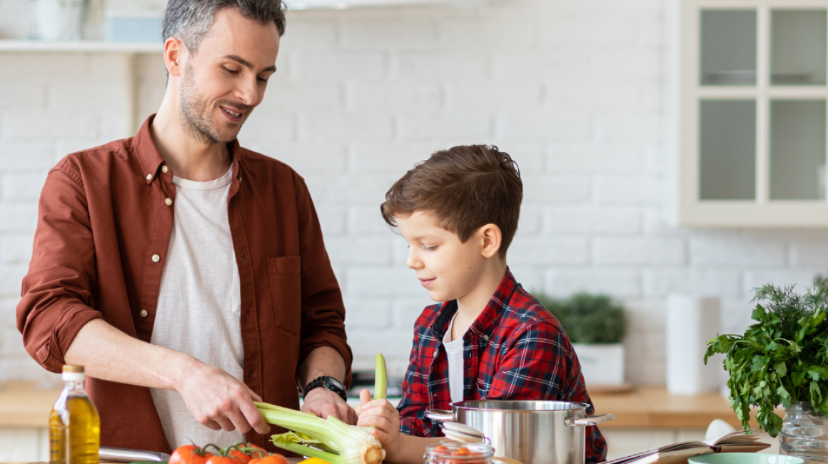 mężczyzna i chlopiec gotują w kuchmni