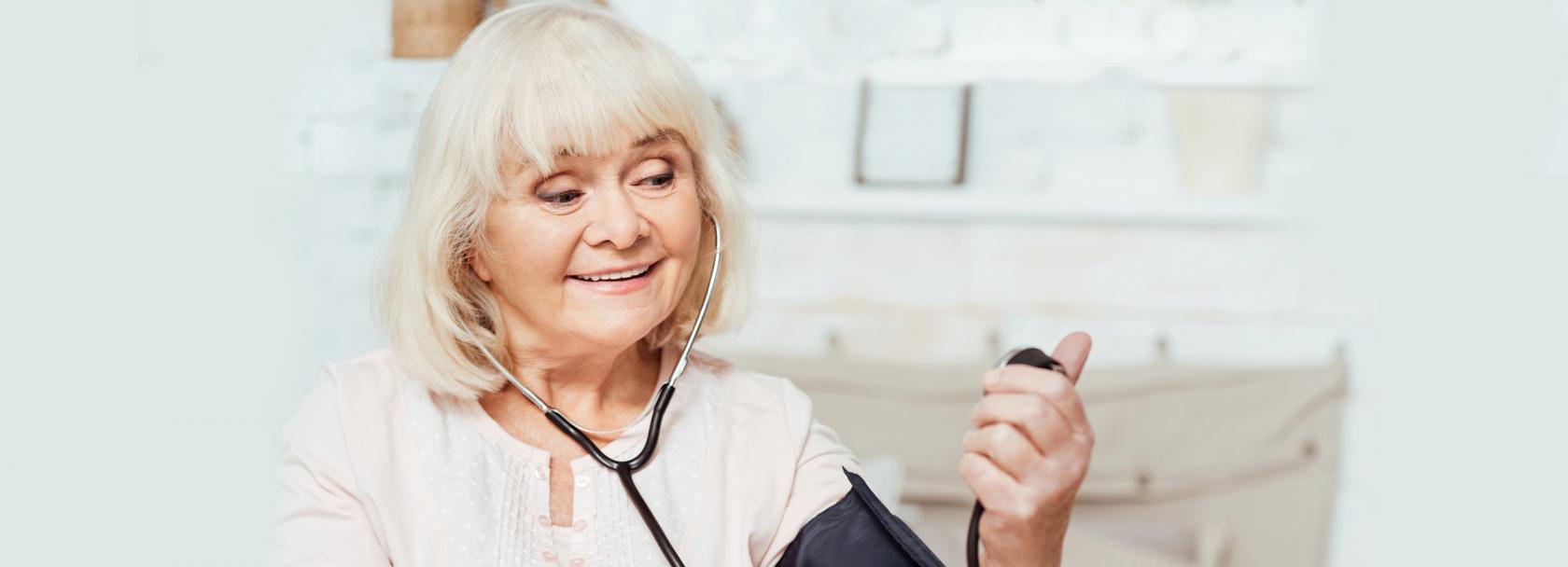 Starsza pani zadowolona z pomiaru ciśnienia