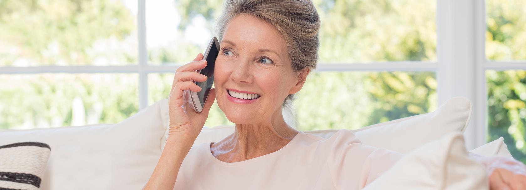 Kobieta na kanapie rozmawia przez telefon