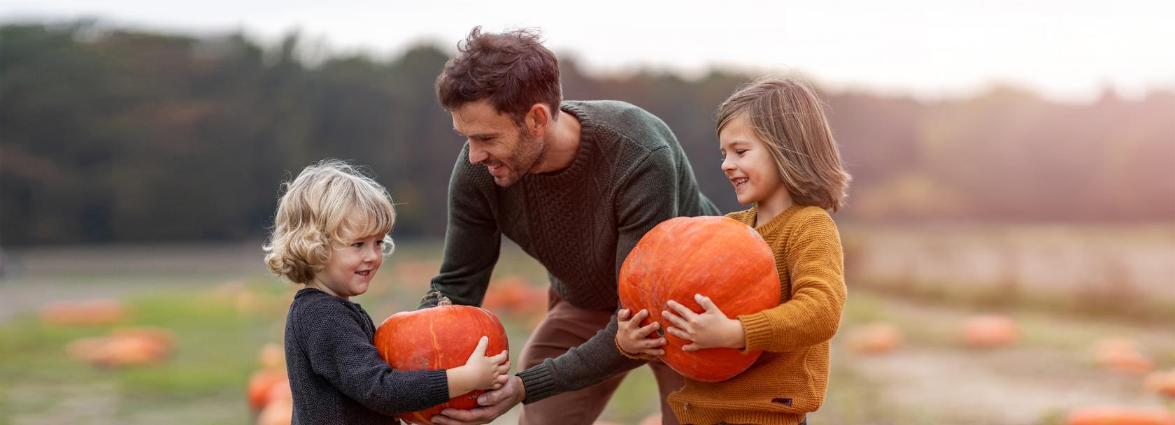 ojciec daje dzieciom dynie